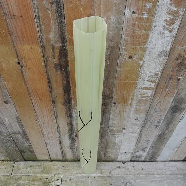 Ashridge Tree Guard protective tube showing spiral ventilation slots against weathered wooden fence background